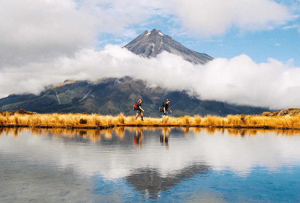 Two people hiking by a lake